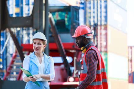 A team of African American men and Caucasian women wear helmets. Work on controlling the loading of...