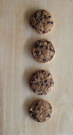 Home made chocolate chip cookies on old wooden plate.