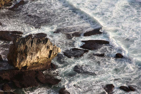 Small rock on bank of Indian Ocean, waves and white surf. Uluwatu, Bali.の写真素材