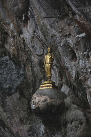 Buddha golden color statue standing on the rock in cave. Thailand.の写真素材