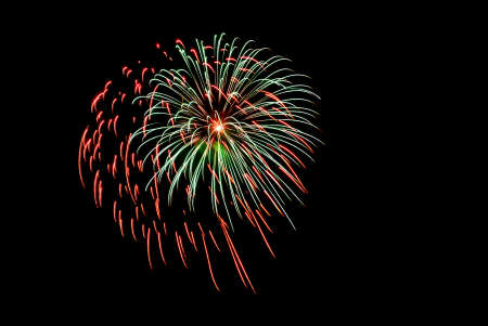 Red and green firework explosion in the night skyの写真素材