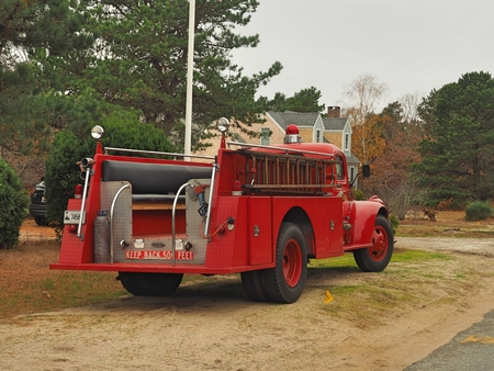 a red fire truck driving down a dirt road
