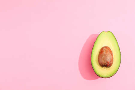 Ripe cut avocado on color background, space for textの写真素材