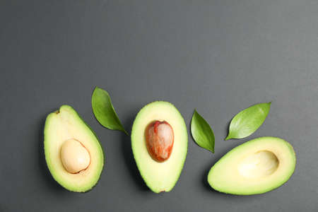 Flat lay composition with ripe avocados on black background, space for text. Top view