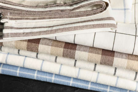 Stack of fabric napkins on black table, close up
