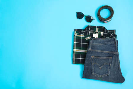 Flat lay composition with shirt, jeans, glasses and belt on color backgroundの写真素材