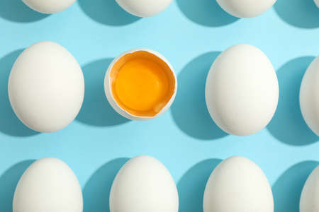Flat lay composition with chicken eggs and half with yolk on color background, space for textの写真素材