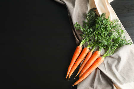 Ripe carrots on black table, space for textの写真素材