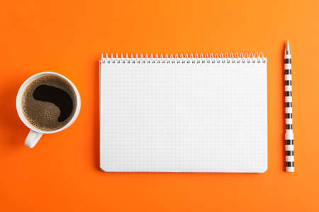Clean copybook with pen and cup of coffee on color background