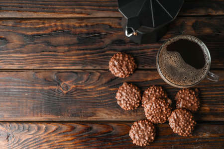 Chocolate cookies and cup of coffee on wooden table, space for textの写真素材