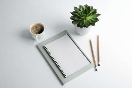 Copybooks, cup of coffee, pencils and succulent plant on white background, space for textの写真素材