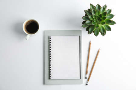Copybooks, cup of coffee, pencils and succulent plant on white background, space for textの写真素材