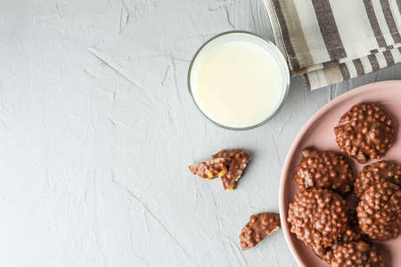 Plate with chocolate cookies and glass of milk on grey table, space for textの写真素材