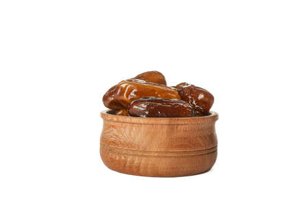 Wooden bowl with dates isolated on white backgroundの写真素材