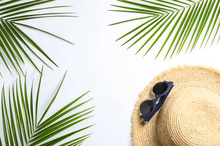 Composition with straw hat, sunglasses and palm leaves on white background. Top view, space for text