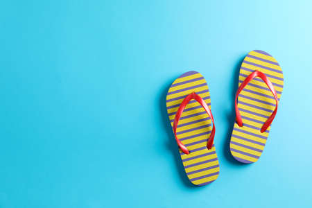 Flip flops on color background, space for text. Summer vacation backdropの写真素材