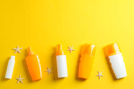 Flat lay composition with sunscreen sprays and starfishes on color background, space for text. Summer vacation backdropの写真素材