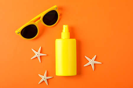 Composition with sunscreen spray, starfishes and sunglasses on color background, space for text. Summer backdropの写真素材