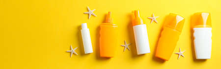 Flat lay composition with sunscreen sprays and starfishes on color background, space for text. Summer vacation backdropの写真素材