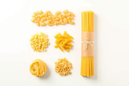 Flat lay composition with different pasta on white background, space for text
