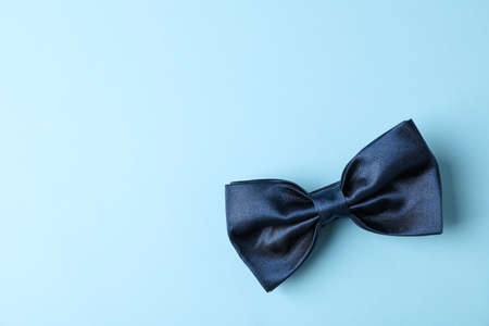Blue bow tie on color background, space for text