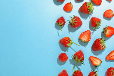 Flat lay composition with strawberries on color background, space for text. Summer sweet fruits and berriesの写真素材