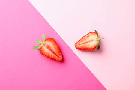 Half of strawberries on two color background, space for text. Summer sweet fruits and berriesの写真素材