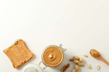 Flat lay composition with peanut butter sandwich, glass jar, peanut and spoon on white background, space for textの写真素材