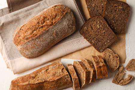 Composition with bakery products, salt and kitchen towel on white background, top view