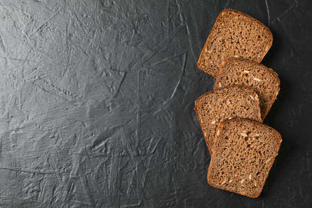 Rye bread pieces on black background, top view and space for textの写真素材