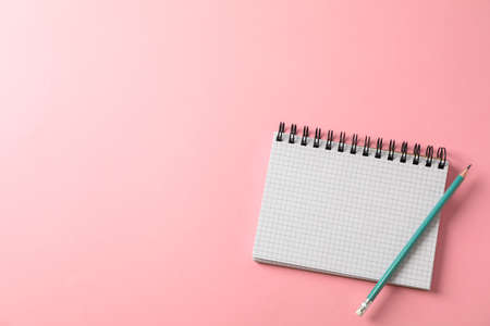 Notebook and pencil on color background, space for text