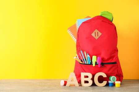 School supplies on grey table against color background, space for textの写真素材