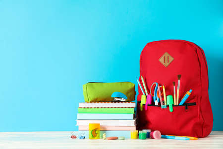 School supplies on wooden table against color background, space for textの写真素材