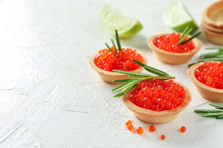 Tartlets with caviar and rosemary on white table, space for textの写真素材