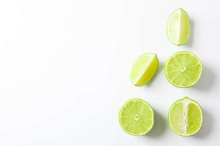 Flat lay composition with limes on white background, space for textの写真素材