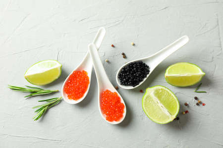Porcelain spoons with caviar, lime slices and spices on light backgroundの写真素材