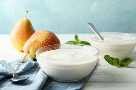 Composition with cream yogurts and fruits on white table, space for textの写真素材