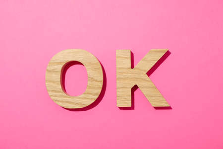 Word OK lined with wooden letters on color backgroundの写真素材