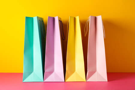 Color paper bags on multicolor background, space for textの写真素材