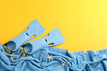 Sea vacation accessories on yellow background, top view