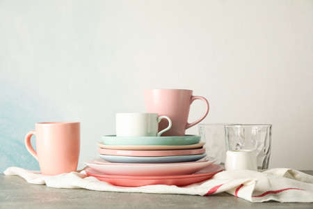 Color plates and cups stacked on grey table, space for textの写真素材