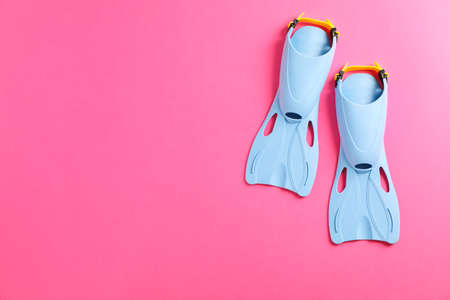 Blue flippers on pink background, space for textの写真素材