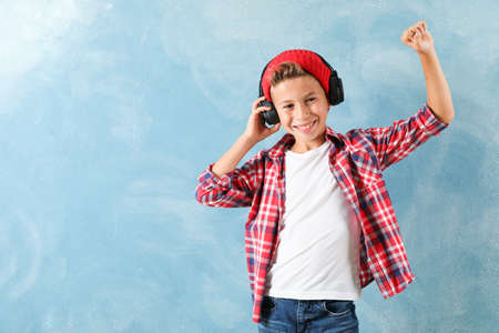Fashion boy in headphones on color background, space for textの写真素材