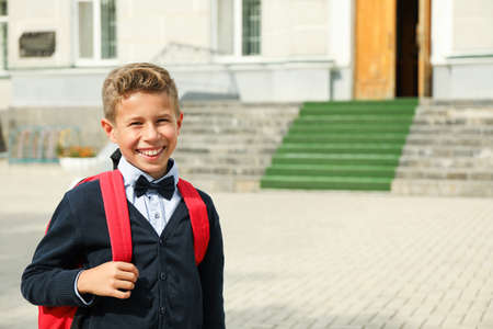 Boy with backpack against school building, space for textの写真素材