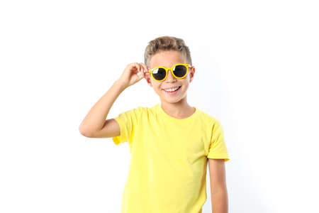 Boy in yellow t-shirt with sunglasses isolated on white backgroundの写真素材