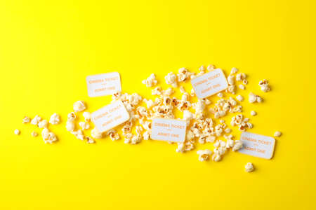 Flat lay composition with popcorn and tickets on yellow backgroundの写真素材