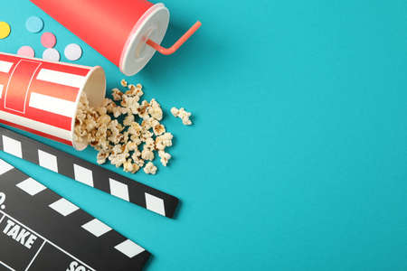 Flat lay. Drink, bucket with popcorn, clapperboard and confetti on color background, copy spaceの写真素材