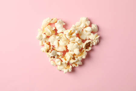 Flat lay composition with popcorn heart on pink background, space for textの写真素材