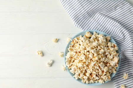 Flat lay composition. Towel and plate with popcorn on white wood backgroundの写真素材