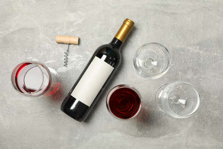 Flat lay composition with bottle and glasses of wine, corkscrew on grey background, copy spaceの写真素材